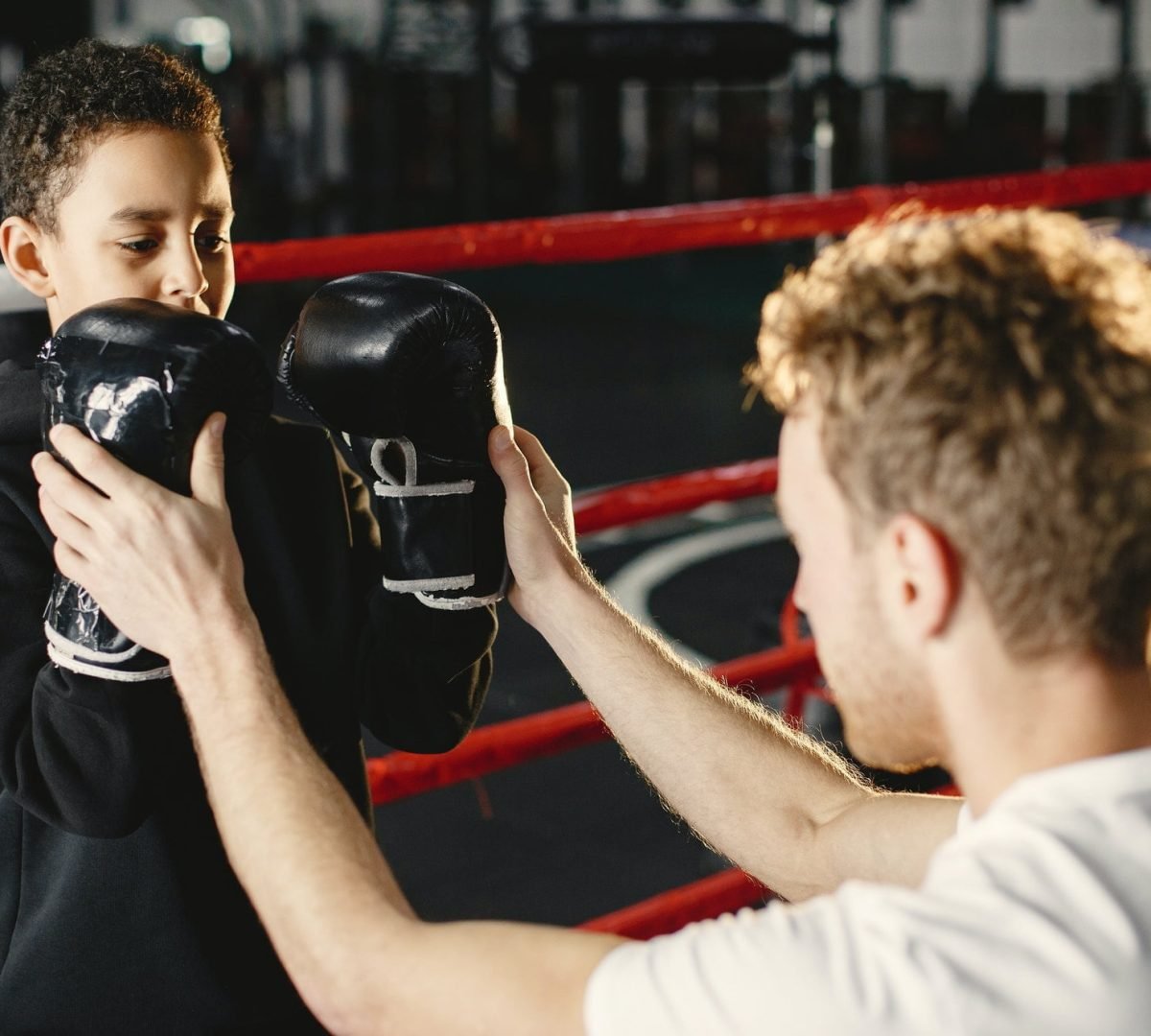 little-boy-in-boxing-gloves-on-ring-with-trainer.jpg
